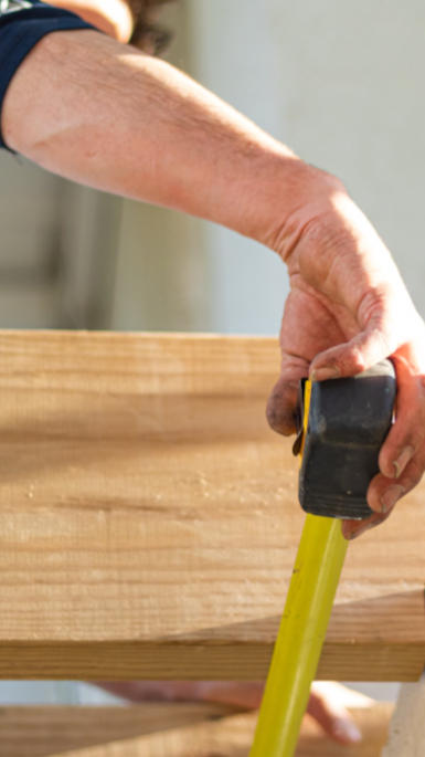 builder using a measuring tape 
