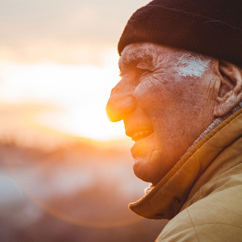 retiree smiling in front of sunset 