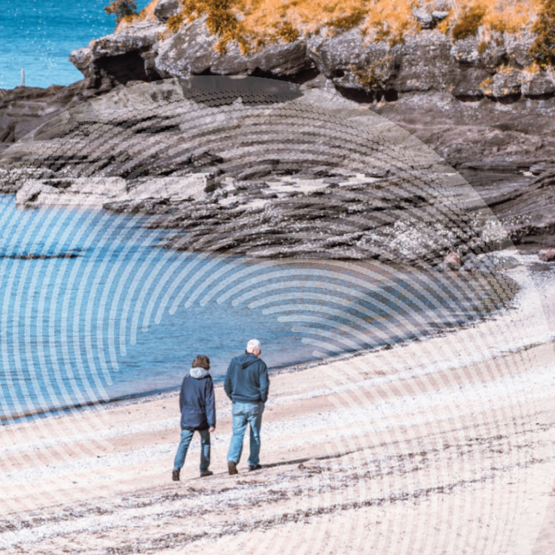 two old people walking on a beach